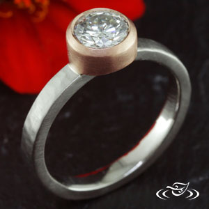 Ring Hammer Diamond Custom Two Toned Rustic Style Mounting Holding A Round Brilliant Cut Center Stone Set In 14kt Rose Gold Bezel Ring Hammer Diamond Custom Two Toned Rustic Style Mounting Holding A Round Brilliant Cut Center Stone Set In 14kt Rose Gold Bezel